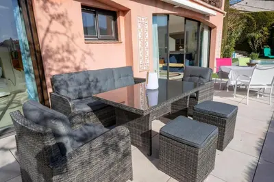 a patio with wicker chairs and a glass table and chairs at 06C-Villa for 8 persons with pool near Nice in Tourrette-Levens