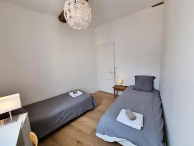 a bedroom with two beds and a chandelier at 