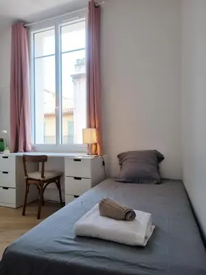 a bedroom with a bed with a desk and a window at 