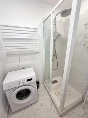a washing machine in a bathroom with a shower at 