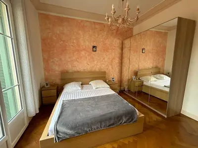 a bedroom with a large bed and a mirror at Le Dante CLIM Balcon in Nice