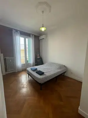 a bedroom with a bed in the middle of a room at Le Dante CLIM Balcon in Nice