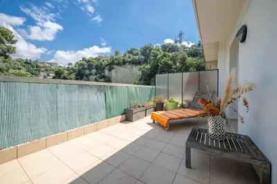 a balcony with a couch and a view of a hill at Ciel d'Orves - Terrasse Spacieuse- Parking privé in Nice