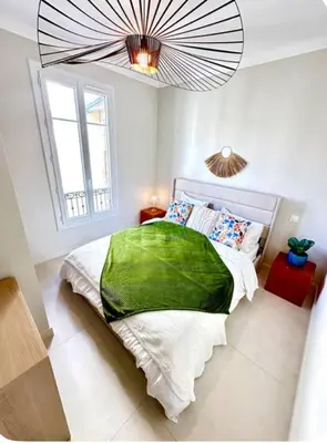 a bedroom with a large bed with a green blanket at 3P neuf et climatisé Nice le Port à 9mn de la mer in Nice