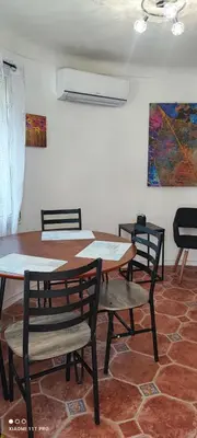 a dining room with tables and chairs and a painting at Villa CALIFORNIA in Nice