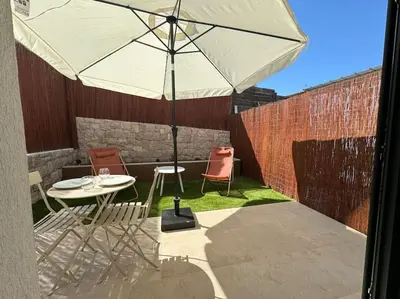 a patio with an umbrella and a table and chairs at Studio avec jardinet proche mer in Cagnes-sur-Mer