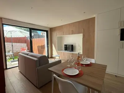 a kitchen and living room with a table and chairs at Studio avec jardinet proche mer in Cagnes-sur-Mer