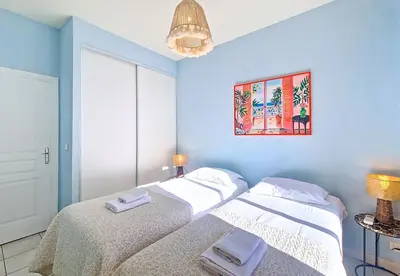 two beds in a bedroom with blue walls at Nestor&Jeeves - PALAIS DU PORT - Balcony - Port Place du Pin in Nice