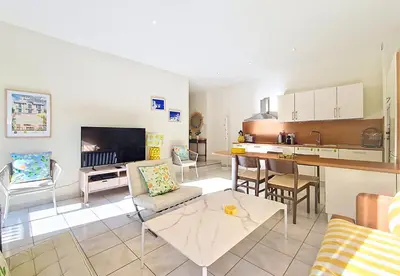 a living room with a table and a kitchen at Nestor&Jeeves - PALAIS DU PORT - Balcony - Port Place du Pin in Nice