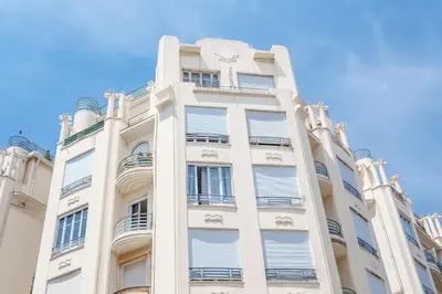 a tall white building with a blue sky in the background at Nice Renting - VERDI - Apartment Charm & Comfort & AirCon in Nice