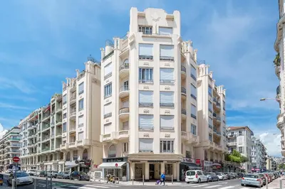 a tall white building on a city street with cars at Nice Renting - VERDI - Apartment Charm & Comfort & AirCon in Nice