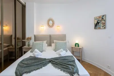 a bedroom with a large white bed with a blanket on it at L54 1BDR Promenade Sea View AC & Balcony in Nice