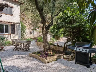 a table and a grill next to a tree at Maison dans l'arrière pays niçois entre mer et montagne in Tourrette-Levens