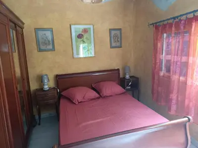a bedroom with a pink bed with two pink pillows at Maison dans l'arrière pays niçois entre mer et montagne in Tourrette-Levens