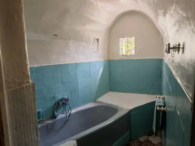 a bath tub in a bathroom with blue tiles at Maison dans l'arrière pays niçois entre mer et montagne in Tourrette-Levens