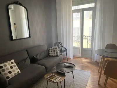 a living room with a couch and a table at Superbe Appartement au Cœur de Nice in Nice