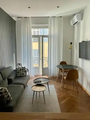 a living room with a couch and a table at Superbe Appartement au Cœur de Nice in Nice