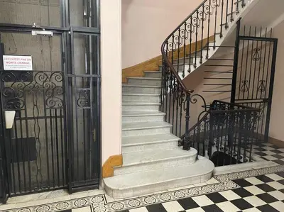 a staircase in a building with a wrought iron gate at Superbe Appartement au Cœur de Nice in Nice