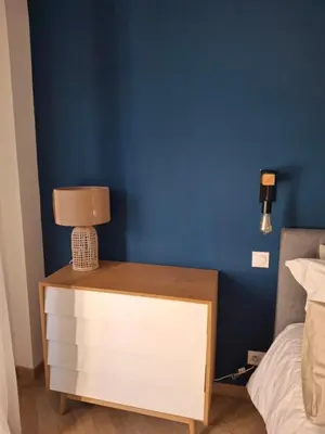 a nightstand with a lamp on it next to a bed at Superbe Appartement au Cœur de Nice in Nice