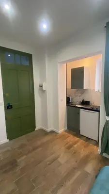 an empty room with a green door and a kitchen at Studio Californie beach in Nice