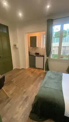 a room with a bed and a kitchen with a window at Studio Californie beach in Nice