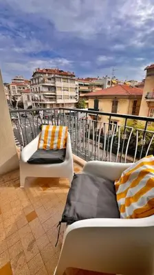 a balcony with a couch and a chair on a balcony at Le Villermont - Liberation Centre Ville in Nice