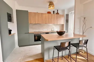 a kitchen with a wooden counter and two chairs at Le Villermont - Liberation Centre Ville in Nice