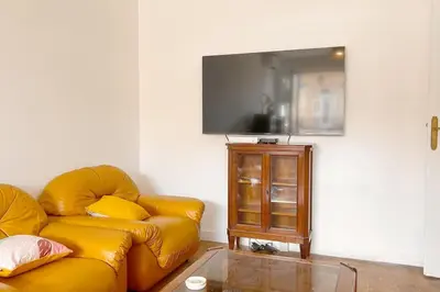 a living room with a yellow couch and a television at Le Villermont - Liberation Centre Ville in Nice
