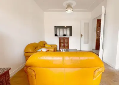a yellow leather couch in a living room at Le Villermont - Liberation Centre Ville in Nice