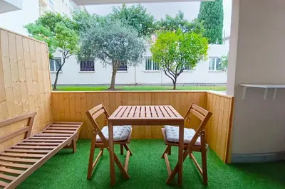 a wooden table and two chairs and a table and a window at Cozy Apt with Balcony - 5 min to the Beach in Nice