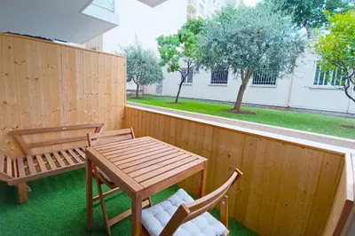 a wooden table and two chairs on a patio at Cozy Apt with Balcony - 5 min to the Beach in Nice