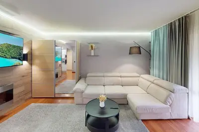 a living room with a white couch and a tv at Cozy Apt with Balcony - 5 min to the Beach in Nice