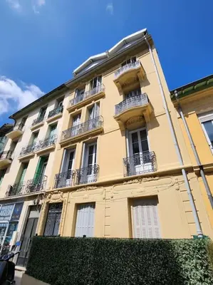 a large yellow building with balconies on the side of it at Nice Fac St Jean D'Angely in Nice