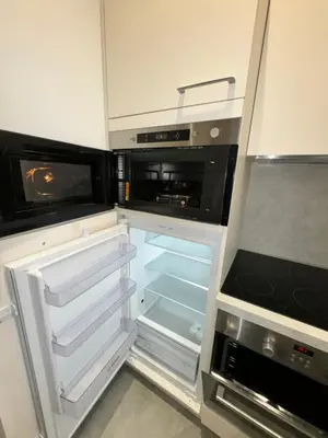 an empty kitchen with an open refrigerator and microwave at LEî in Beaulieu-sur-Mer