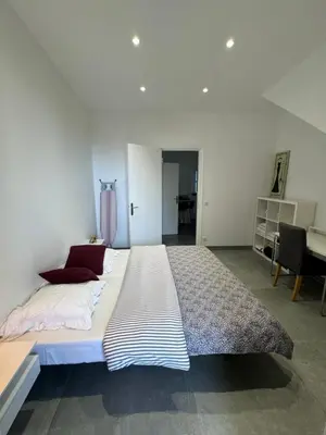 a large bed in a white room with a piano at LEî in Beaulieu-sur-Mer
