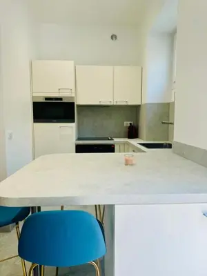 a kitchen with a table and two blue chairs at LEî in Beaulieu-sur-Mer
