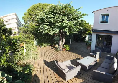 a deck with chairs and a table and a tree at Villa spacieuse, totalement adaptée aux normes PMR in Nice