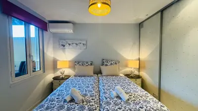 a bedroom with a bed with two lamps and a window at Eze flat with terrace sea view and mountain view in Èze