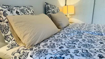 a bed with blue and white sheets and pillows at Eze flat with terrace sea view and mountain view in Èze