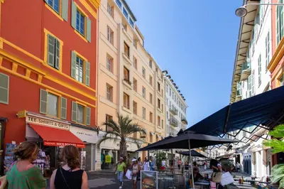 a group of people walking down a street with buildings at L52 2BDR Massena central, 2 min from the beach AC in Nice