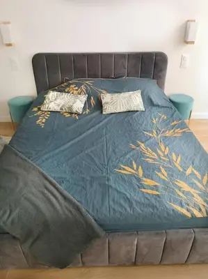 a bed with a blue comforter and two pillows on it at Chez L'Hadriana, 2x AC clim Wi-Fi,newly renovated in Nice