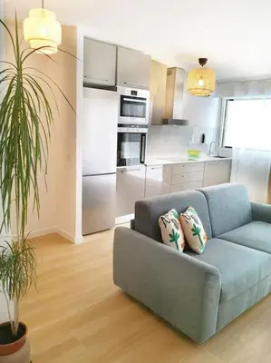 a living room with a blue couch and a kitchen at Chez L'Hadriana, 2x AC clim Wi-Fi,newly renovated in Nice
