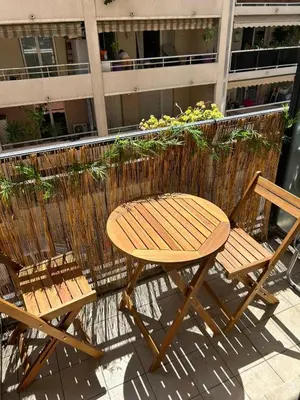 a wooden table and two chairs next to a building at Tournesol de Nice in Nice
