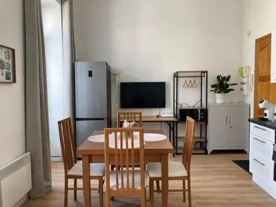 a kitchen with a table and chairs and a refrigerator at LocaNice Masséna in Nice