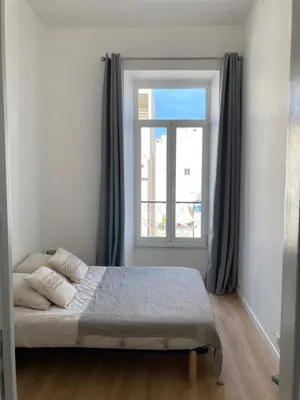 a bedroom with a bed in front of a window at LocaNice Masséna in Nice