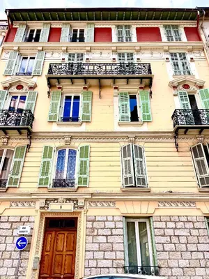 a yellow building with windows and a balcony at Duplex moderne port de Nice in Nice