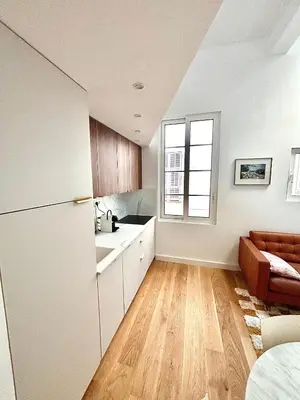 a kitchen with a refrigerator and a couch in a room at Duplex moderne port de Nice in Nice