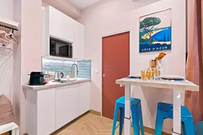 a small kitchen with blue stools and a counter top at Nice Renting - SPITALIERI - Chic & Cosy Art Deco Nest Nice Étoile in Nice
