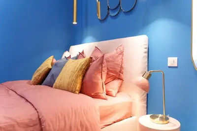 a white couch with pillows on it in a blue room at Nice Renting - SPITALIERI - Chic & Cosy Art Deco Nest Nice Étoile in Nice