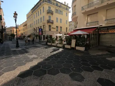 a street with umbrellas and plants on a city street at Royal Promenade in Nice